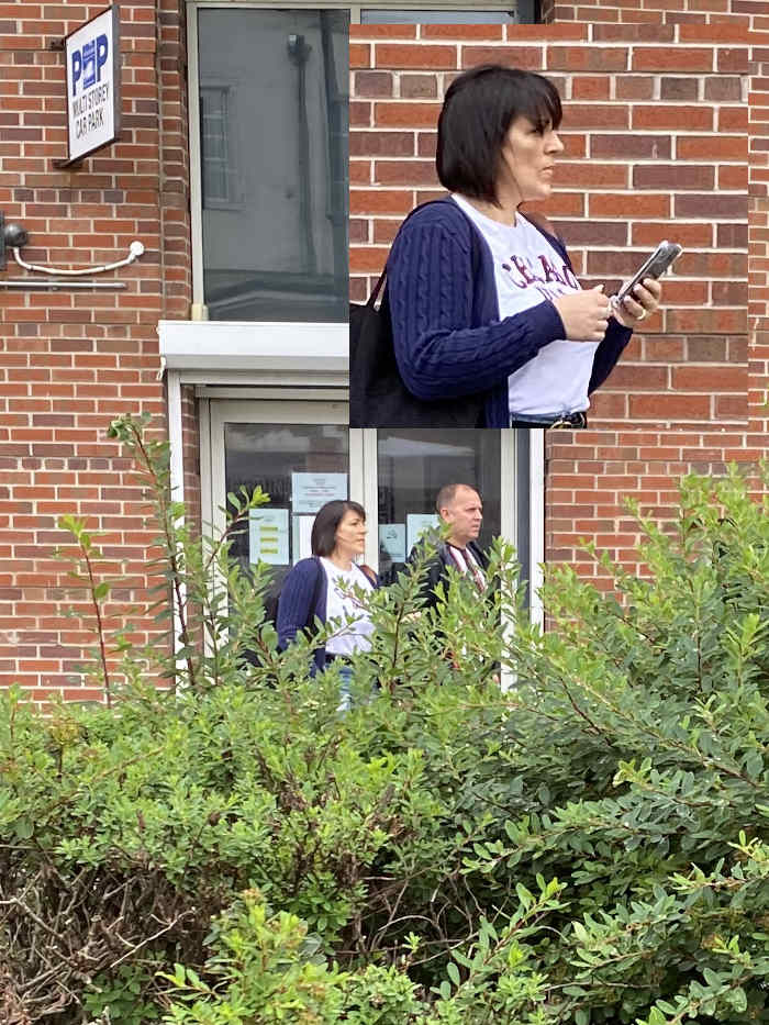 Collage of two photos. The top photo depicts a woman with short dark hair, wearing a dark blue cardigan and white t-shirt, looking at her phone outside a brick building. The bottom photo shows a couple, partially obscured by bushes, standing in front of the same building's entrance. The building appears to be some kind of office or public building, as indicated by a sign for Walt Storey Car Park. The overall impression is a candid shot of people outside a building.