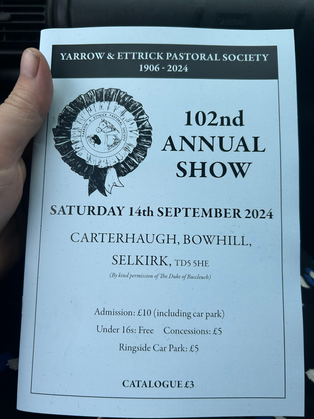Brochure for the 102nd Annual Show of the Yarrow & Ettrick Pastoral Society. The show will be held on Saturday, September 14th, 2024, at Carterhaugh, Bowhill, Selkirk. The brochure includes admission prices and details about parking. The design incorporates the society's logo, a rosette with images of sheep, a cow, and a horse, reflecting the pastoral nature of the event. The overall impression is that of a traditional agricultural show.