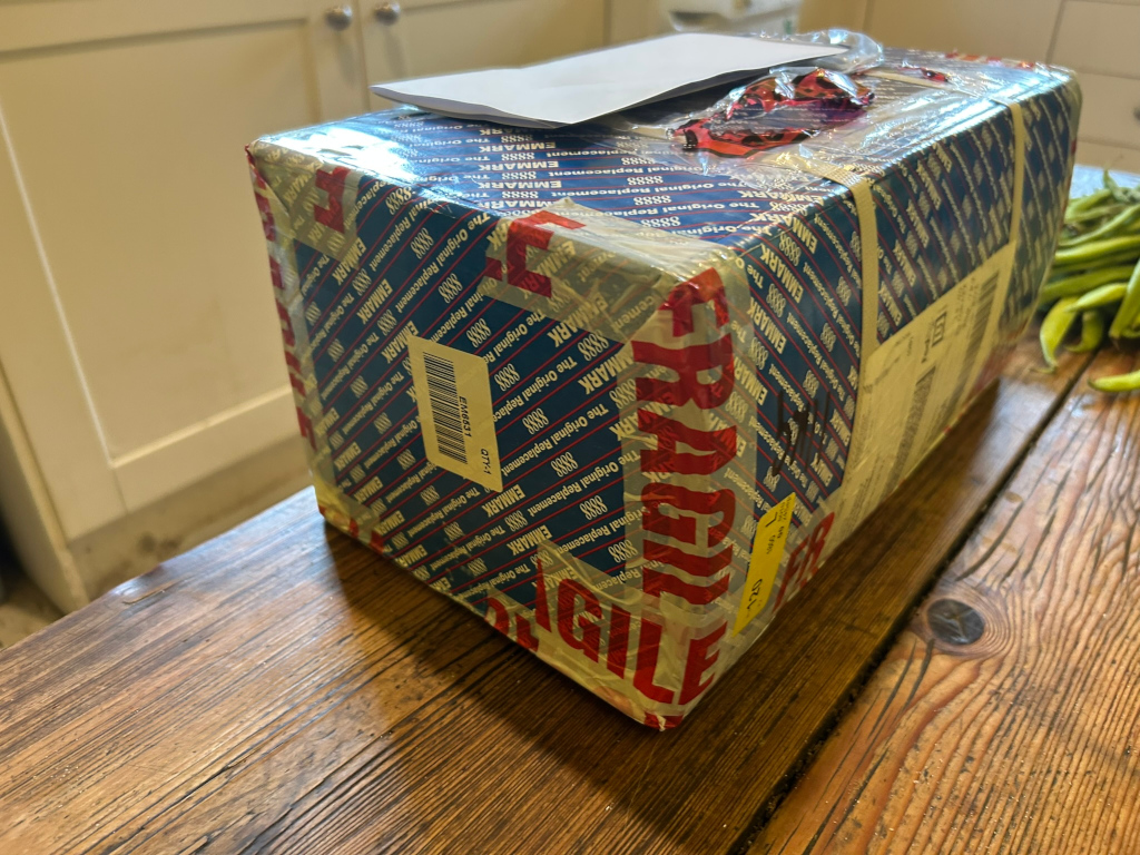 Rectangular package wrapped in multiple layers of protective packaging. The outer layer displays the word Agile prominently in large red lettering.